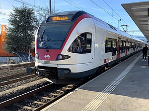 White train on tracks next to platform