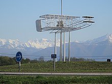 Photographie en couleurs d'un rond-point, avec la reproduction d'un ancien avion.