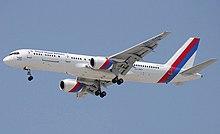 Side view of airliner in flight, with extended landing gear