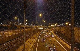 Autobahn und S-Bahn-Gleise bei Nacht