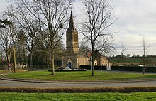 Photographie d'une église derrière deux arbres dénudés