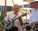 Man playing a four-string banjo.