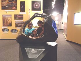 Children posing behind a replica of the Tucson Meteorite at the Arizona Museum of Natural History[79]