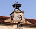 Viraventos, campá, reloxo e escudo na casa do concello de Tomiño.