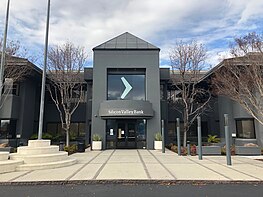 An entrance to an office building with the words "Silicon Valley Bank" above the doorway and the company's rightward-pointing chevron logo in the window above it.