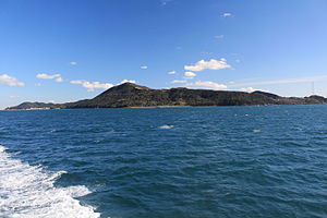 海上の鳥羽港方面から望む菅島（左に菅島漁港、中央に大山、右端に採石場、2016年1月9日）