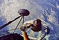 Den Alan Shepard gëtt no senger Landung am Mier vum Helikopter héichgezunn