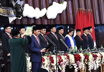 An presidente kan Indonesya na si Joko Widodo asin mga kaapil kan parlyamento nakasulot nin peci bilang parte kan nasyunal na kasulutan.