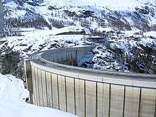 Un barrage au milieu de montagnes enneigées.