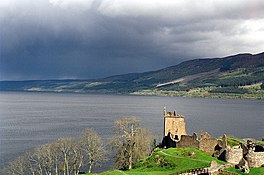 A lake with a ruined castle in the foreground