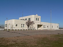 One-story building with two-story central section; rounded corners