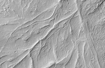 Crêtes sinueuses dans la région de Medusae Fossae, au sud d'Amazonis Planitia, illustrant les reliefs inversés révélant d'anciens lits de cours d'eau durcis par cimentation, vues par MRO le 8 avril 2008[110].