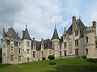 Photographie en couleurs d'un château aux multiples tours et tourelles.