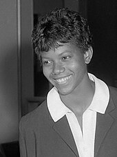 Schwarzweißfoto der lächelnden Wilma Rudolph im dunklen Blazer mit weißer Bluse