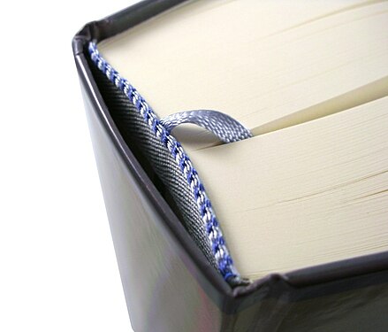 Hardcover book from above, showing binding and endbands. This book also includes a ribbon for use as a bookmark.