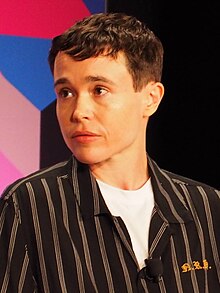 Headshot of Elliot Page speaking at the 2023 National Book Festival. He is a young white man with short dark hair, wearing a white shirt and a dark blazer.