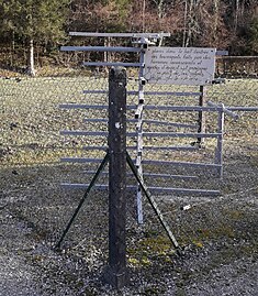 Un tournet en métal protégé par un grillage, avec une plaque blanche.