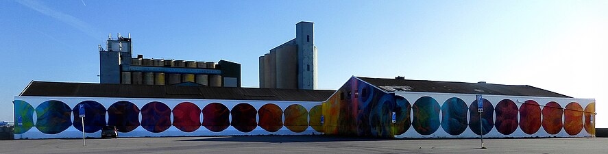 En 90 meter lång muralmålning vid en parkeringsplats i Ystads hamn.