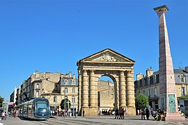 Photographie de la place de la Victoire, avec un grand ciel bleu et un tramway qui passe sur la gauche.