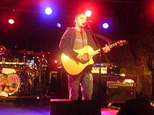 Image of Plan B playing guitar at a concert