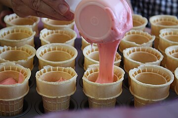 Cake batter is poured into an ice cream cone prior to baking.