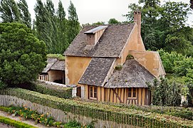 Réchauffoir au hameau de la Reine ; Petit Trianon, parc ; ce hameau d'agrément est commandé durant l'hiver 1782–1783 par la reine Marie-Antoinette, souhaitant s'éloigner des contraintes de la cour de Versailles, avec la nostalgie d'une vie plus rustique, dans un décor de nature inspiré par les écrits de Rousseau.