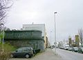 Maaskade met links een overblijfsel van de voormalige spoorwegviaduct en rechts met monument de 2 voormalige brugwachtershuisjes van de Oude Willemsbrug.