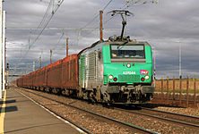 BB 27044 tirant des wagons de grumes vides passe en gare de Monnerville.