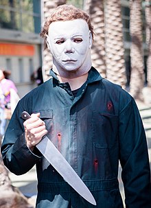 Photo d'un homme avec un masque blanc et un couteau.