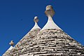 Harriz landukato pinakulua zaharberritutako trullo konoen gainean (Alberobello)