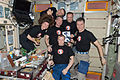 Expedition 27 crew members pose for a photo near the galley in the Zvezda Service Module of the ISS in honor of the 50th anniversary of the spaceflight of Yuri Gagarin, the first human launched in space, on 12 April 1961.