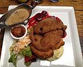 Schnitzel yang mengandungi anak lembu, babi dan ayam, disajikan dengan kentang lecek, akar bit, sos krim cendawan dan salad sampingan