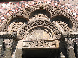 The carving of the polychrome porch of the Saint-Michel-D'aiguilhe chapel, the Aiguilhe, Haute-Loire, France, (11th century), has paired mermaids, and the Lamb of God