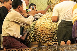 Worshippers adding gold leaf to the statue