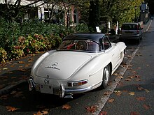 A hard-top roadster parked on a street