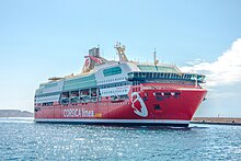 A red-painted ship arriving at harbour