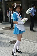 Chica portando un cosplay de sirvienta, promocionando un restaurante cosplay en Akihabara