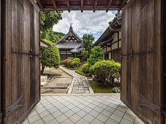 Grand porche en bois avec double porte ouverte conduisant au jardin du temple bouddhiste Isshinin, à l'intérieur du vaste complexe de Chion-in. Juin 2019.