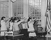 Amerikanske skoleelever hilser flagget med Pledge of Allegiance (troskapsløfte) og høyrearmen utstrakt i Bellamyhilsen ca. 1941. Denne hilsenen ble avskaffet i 1942.