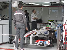 Photographie de Sergio Pérez, à bord de la Sauber C30 dans les stands de Melbourne