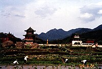 A distant view with farmers working in the foreground