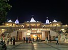 Night image of a three-shikhared two-story front-facing facade of a major temple tourist attraction in Adalaj.