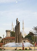 Dezember: Himmelragendes in Shkodra: Monument am zentralen Platz, Englischer Turm, Minarette und Kirchenturm