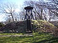 Een klokkenstoel op een prehistorische grafheuvel naast een middeleeuwse kerk in Frederikshavn Kommune, Noord-Jutland