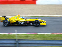 Photographie d'une monoplace jaune vue de profil, dans son ensemble, sur un circuit.