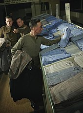 En 1944, dans un centre de démobilisation au Royaume-Uni, un militaire fait son choix parmi des chemises civiles.