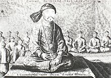 Black-and-white print of a man with small eyes and a thin mustache wearing a robe, a fur hat, and a necklace made with round beads, sitting cross-legged on a three-level platform covered with a rug. Behind him and much smaller are eight men (four on each side) sitting in the same position wearing robes and round caps, as well as four standing men with similar garb (on the left).