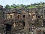 Turistas visitando un templo cortado na roca