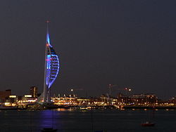 Portsmouth kikötői látképe éjszaka, előtérben a 170 méter magas Spinnaker Tower épülete