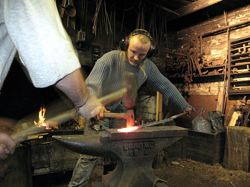 Metiarta forĝisto kaj metalbatisto kune laboras